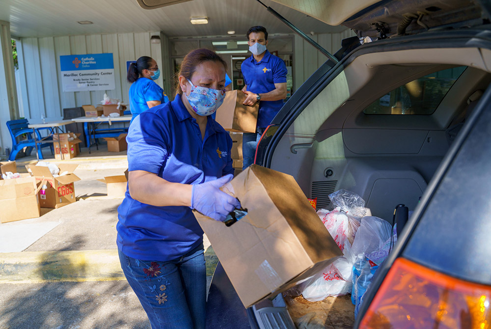 Staff with Catholic Charities Dallas load boxes of food into cars of families at a distribution center in July 2020. Since the coronavirus pandemic triggered shutdowns across America last March, the agency has distributed 7 million pounds of food to more 
