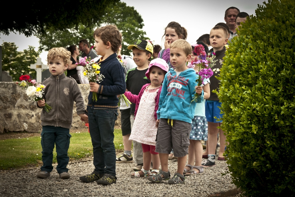 Schoolchildren in Graignes, France, wait to place flowers on a memorial during a ceremony on June 5, 2015, honoring those who died during the Battle of Graignes in 1944. (Wikimedia Commons/U.S. Army/Capt. Saska Ball)