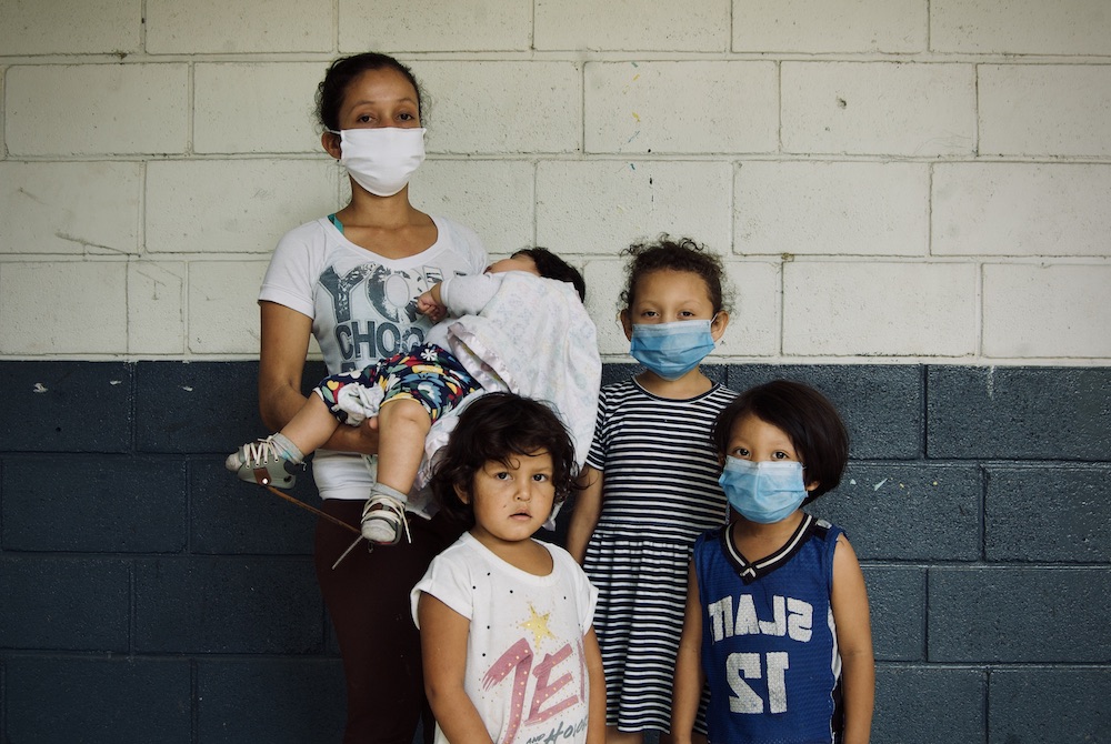 Jessy Nohemí Rosa Durón, 24, stands with her three children and another girl in a shelter in Comayagüela, Honduras, for people displaced by the hurricanes. (Fernanda Aguilar)