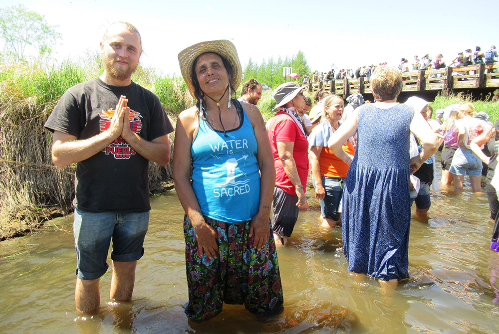 Indigenous activist and writer Winona LaDuke cools off with other protesters in the Mississippi River headwaters. (Claire Schaeffer-Duffy)