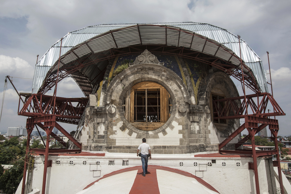 Parishioner Carlos Jimenez Taboada walks on the exterior of the central nave towards the quake-damaged dome of the Our Lady of the Angels Catholic Church in Mexico City, Mexico Aug. 7. (AP/Ginnette Riquelme)