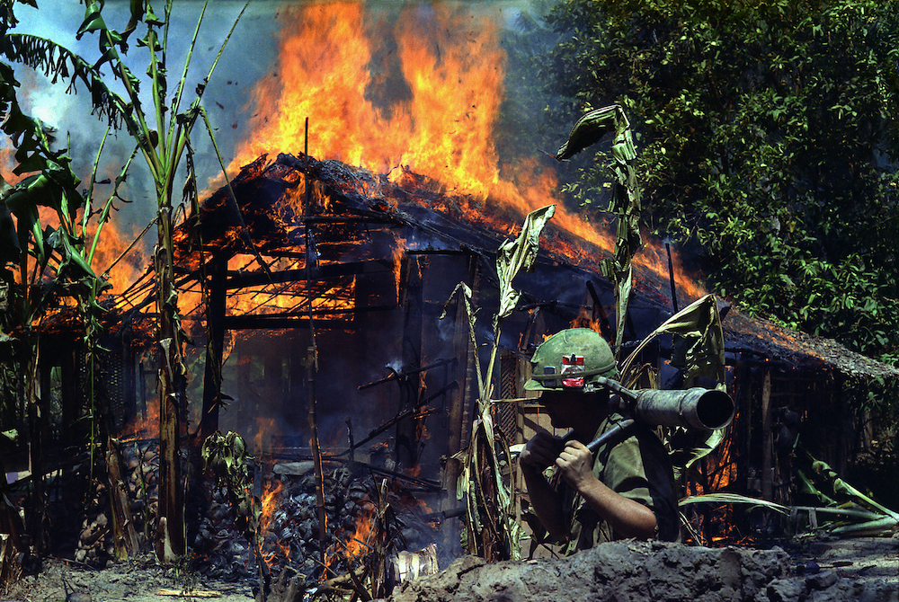 Pfc. Raymond Rumpa of St. Paul, Minnesota, in Mỹ Tho, Vietnam, a Viet Cong base camp burning April 5, 1968 (National Archives/U.S. Army/Dennis Kurpius) Pfc. Raymond Rumpa of St. Paul, Minnesota, in Mỹ Tho, Vietnam, a Viet Cong base camp burning April 5, 1968 (National Archives/U.S. Army/Dennis Kurpius)