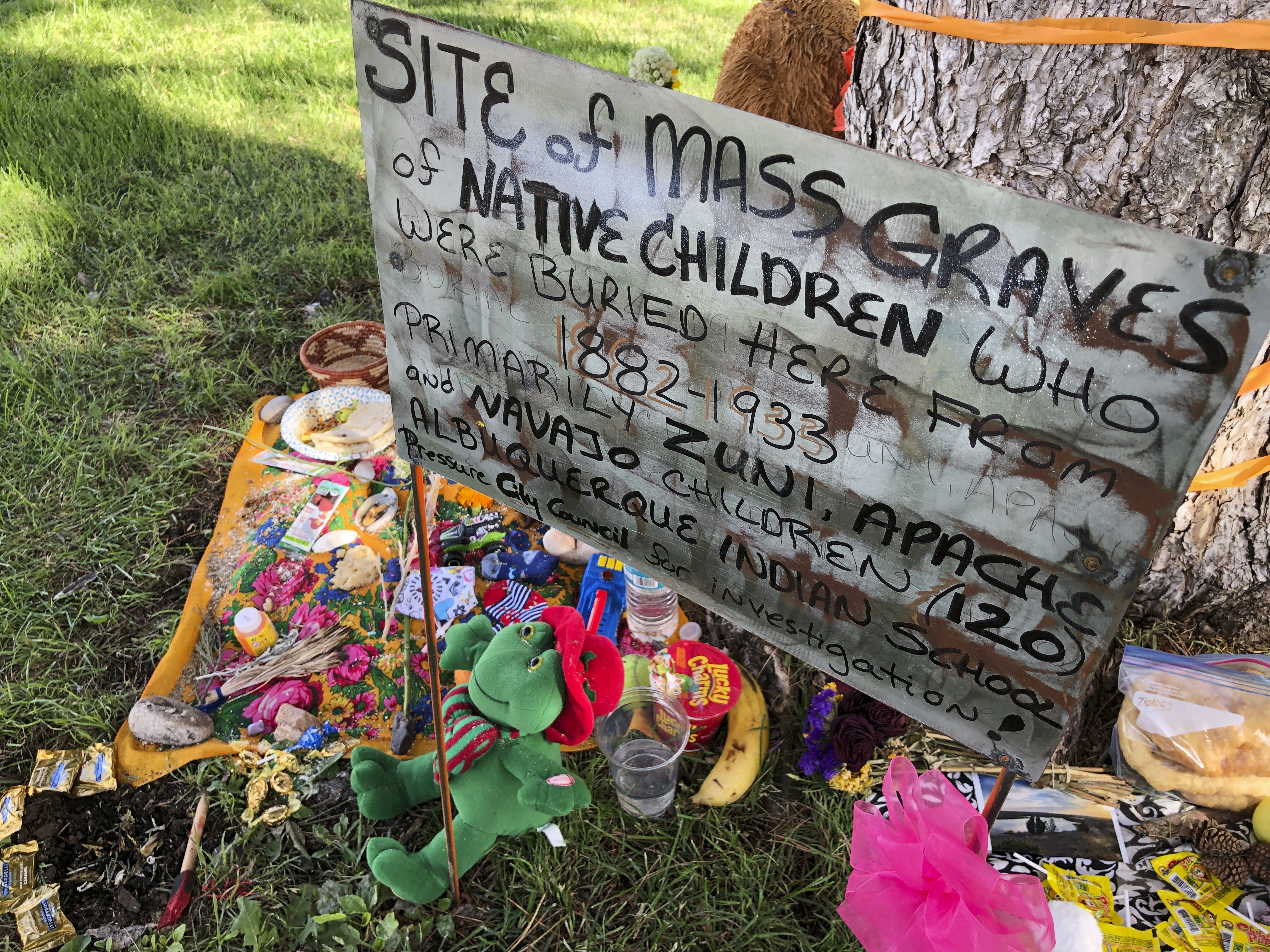 A makeshift memorial for the dozens of Indigenous children who died more than a century ago while attending a boarding school that was once located nearby is displayed under a tree in Albuquerque, N.M., on July 1, 2021 (AP Photo/Susan Montoya Bryan, File)