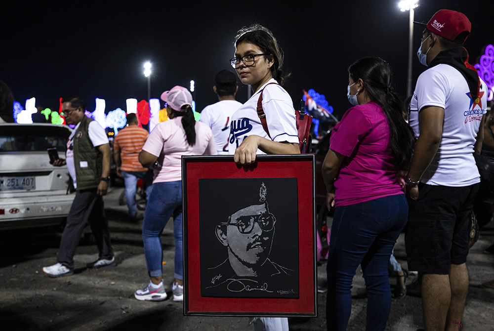 A youth carries a portrait of Nicaraguan President Daniel Ortega during commemorations late Sunday, July 18, for the anniversary of the triumph of the 1979 Sandinista Revolution that toppled dictator Anastasio Somoza in Managua, Nicaragua. (AP Photo)