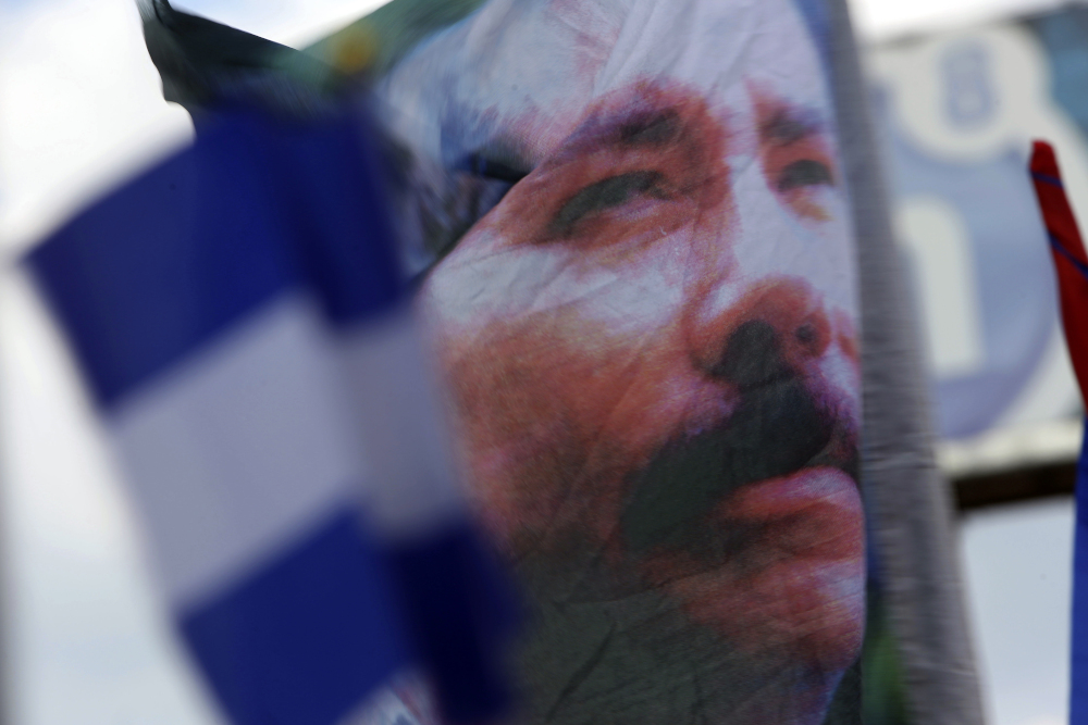 A banner emblazoned with an image of Nicaragua's President Daniel Ortega is waved by an Ortega supporter in Managua, Nicaragua, April 30, 2018. (AP file/Alfredo Zuniga)