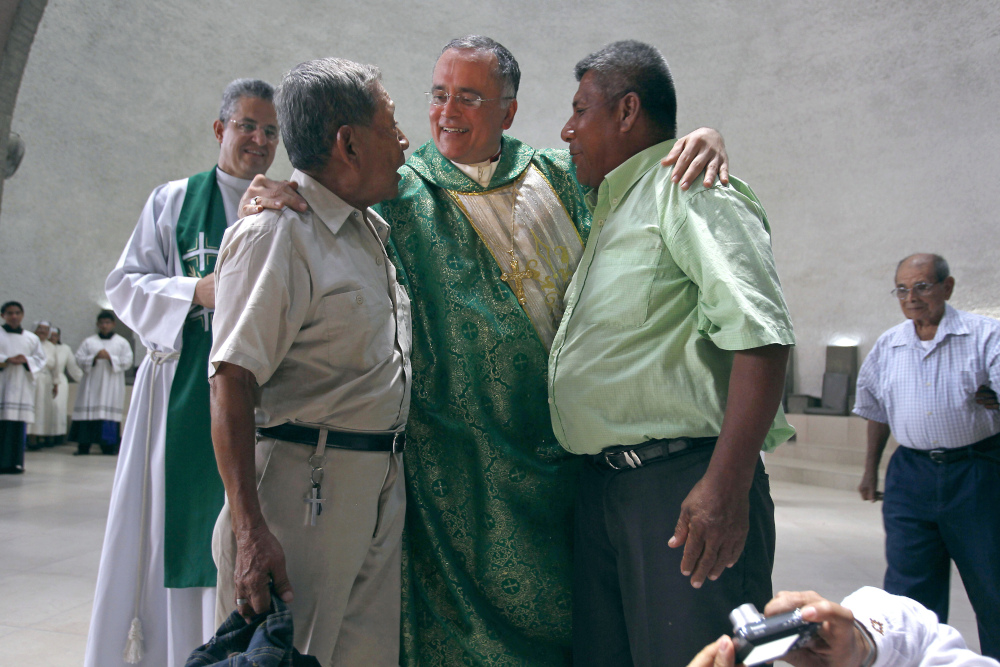 Msgr. Silvio Baez, center, auxiliary bishop of the Archdiocese of Managua, embraces members of the National Elderly Union, in the Metropolitan Cathedral in Managua, Nicaragua, June 23, 2013. (AP file/Esteban Felix)