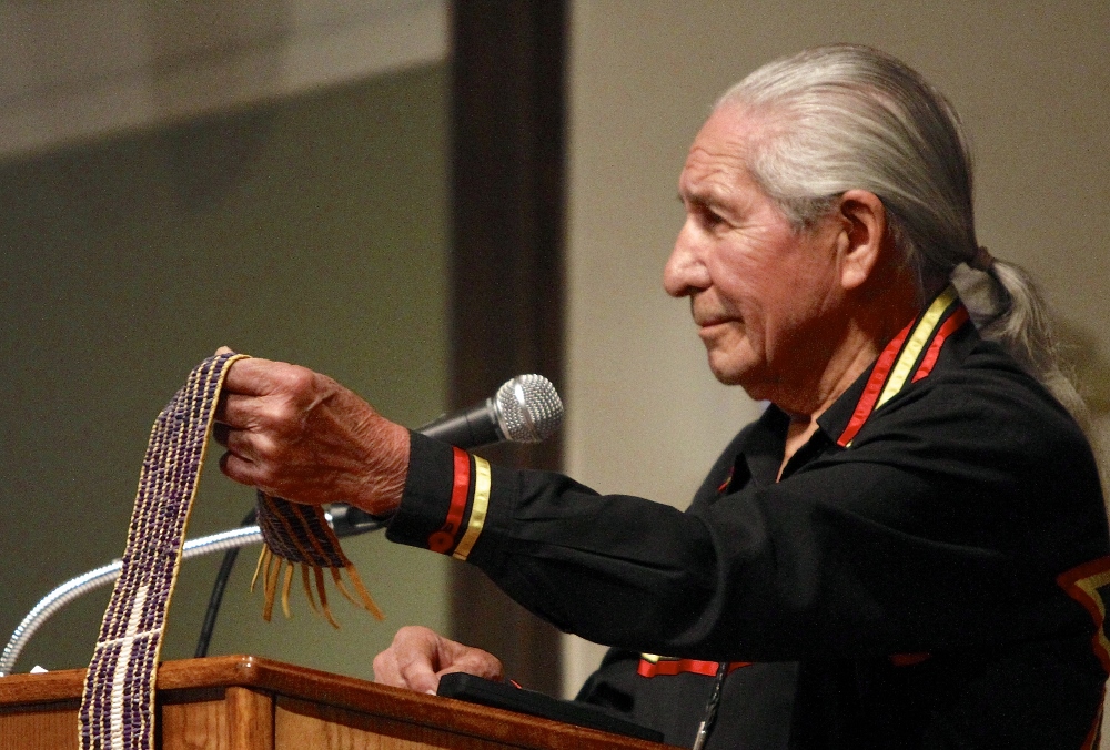 At a 2013 event at Le Moyne College called "Listening to the Wampum," Oren Lyons holds the Jesuit Belt, or the Remembrance Belt, which depicts the history of contact between French Jesuits and the Onondaga in the 1650s. (Michael Davis)