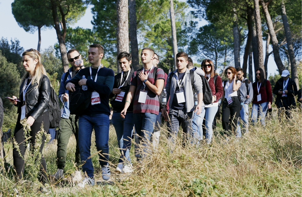 Young people participate in a pilgrimage hike from the Monte Mario nature reserve in Rome to St. Peter's Basilica at the Vatican Oct. 25, 2018. Participants in the Synod of Bishops on youth and young people from Rome parishes took part in the hike. (CNS) Young people participate in a pilgrimage hike from the Monte Mario nature reserve in Rome to St. Peter's Basilica at the Vatican Oct. 25, 2018. Participants in the Synod of Bishops on youth and young people from Rome parishes took part in the hike. (CNS)