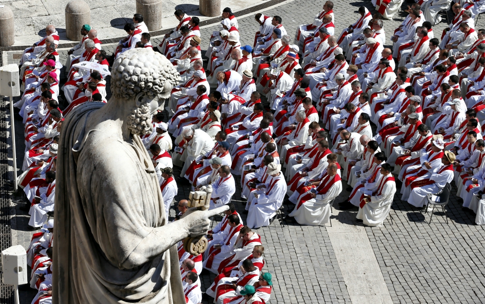 Priests sit below the statue of St. Peter as Pope Francis celebrates Mass marking the feast of Sts. Peter and Paul in St. Peter's Square at the Vatican June 29. (CNS/Paul Haring)