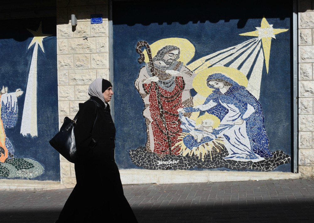A Palestinian woman walks by a mosaic of the Nativity in Bethlehem, West Bank, Dec. 17, 2018. (CNS/Debbie Hill)