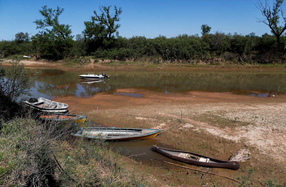 Stranded boats are seen on the waters of a dried branch of the Paraná River at the delta islands near Rosario, Argentina, in September. The lack of water in the Paraná is forcing fishing communities to move, while deforestation in the Amazon is disrupting
