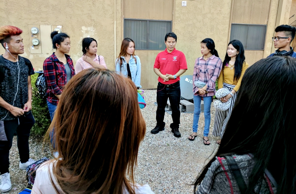 Fr. Shiareh Marino (in red shirt) gathers the group of young Karenni Catholics for prayer Aug. 31 in Phoenix before they leave for a retreat in Rogers, Arkansas. (Peter Tran)