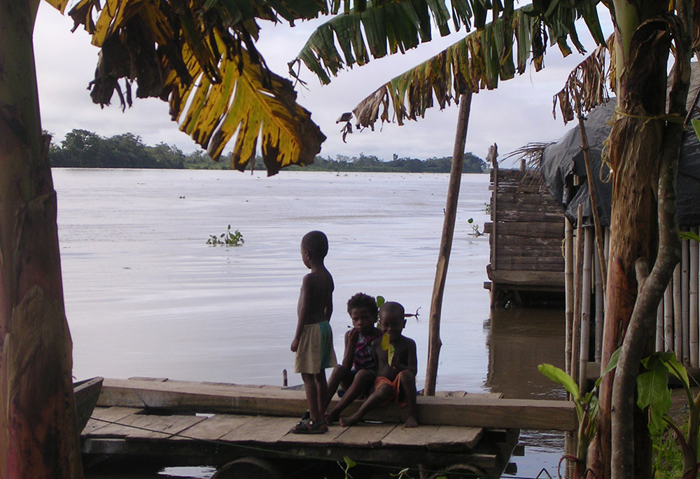 A child looks out on the Atrato River in the Chocó region of Colombia. (Courtesy of ABColombia)