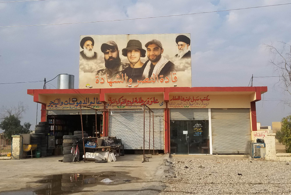 In Bartella, a billboard shows the faces of Shabak martyrs in the fight against ISIS, with Iran-aligned religious leaders looking on. Before ISIS, the town was mostly Christian. (Xavier Bisits) In Bartella, a billboard shows the faces of Shabak martyrs in the fight against ISIS, with Iran-aligned religious leaders looking on. Before ISIS, the town was mostly Christian. (Xavier Bisits)