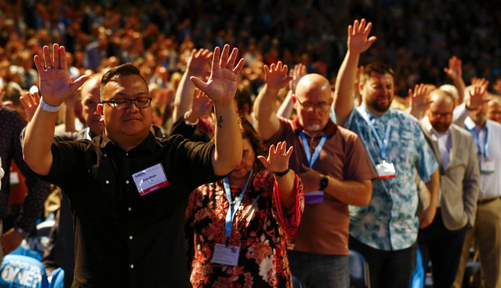 Members of the Southern Baptist Convention and guests lift their hands in prayer during the SBC's annual meeting in Birmingham, Alabama, June 11. (RNS/Butch Dill)
