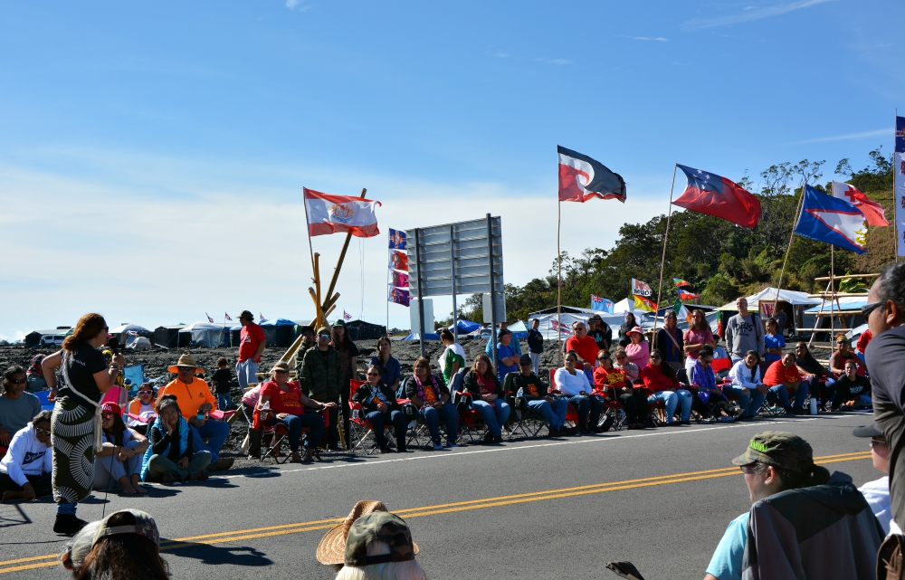 Pua Case, left, speaks to other protectors at the camp blocking the access road to Mauna Kea. (RNS/Jack Jenkins)