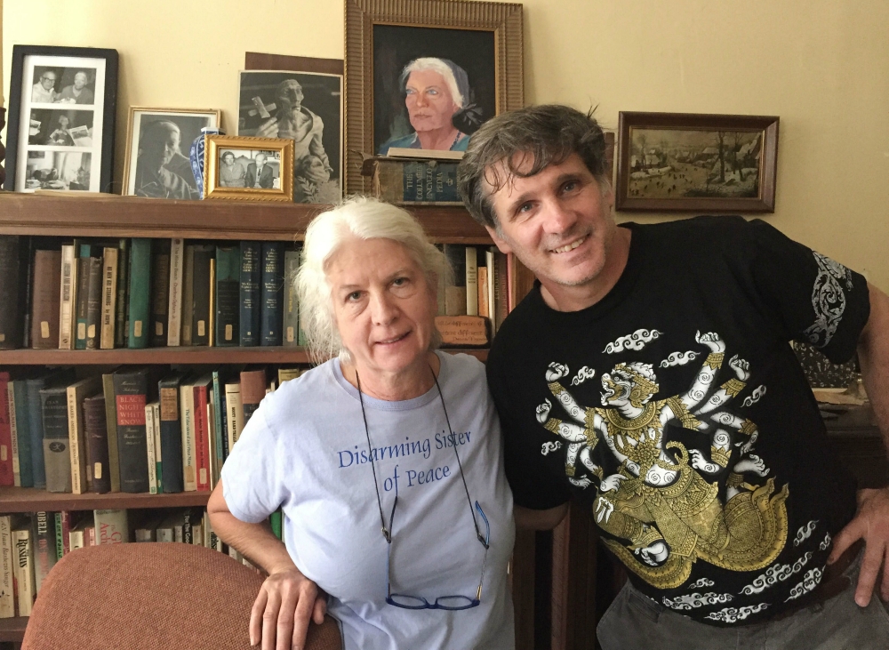Martha Hennessy, left, and Carmen Trotta are two of the Kings Bay Plowshares 7. Hennessy is the granddaughter of Dorothy Day, whose likeness appears in the painting on the bookcase. (RNS/Yonat Shimron)