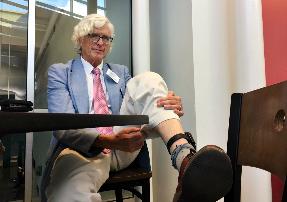 Patrick O’Neill, one of the Plowshares 7, shows his ankle monitor. (RNS/Yonat Shimron)