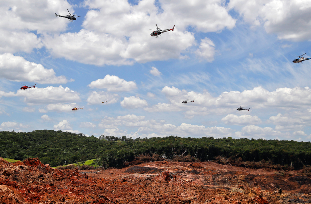 Helicopters hover over an iron ore mining complex to release thousands of flower petals paying homage to the victims killed after a mining dam collapsed in Brumadinho, Brazil, Feb. 1, 2019. (AP/Andre Penner)