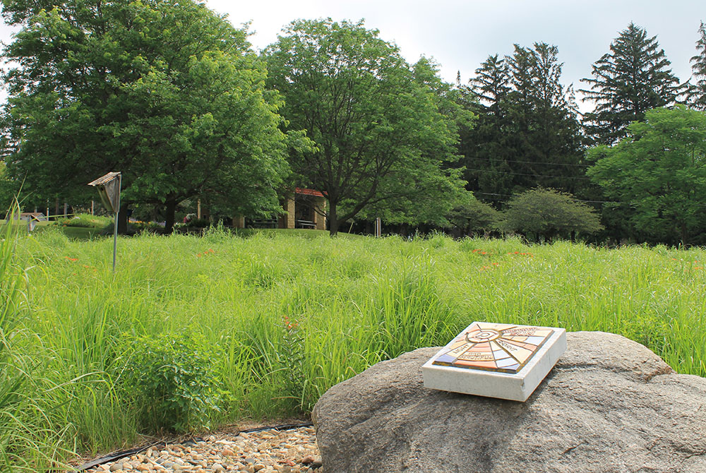 A tablet rests on a rock in a meadow that is part of the conservation easement of the Sisters of St. Francis of Rochester, Minnesota. (EarthBeat photo/Brian Roewe)