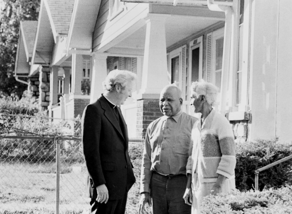 In 1977, Fr. Norm Rotert talks with Robert and Delia Harris, who were living in a home they got through the Blue Hills Homes Corporation, founded by Rotert in Kansas City, Missouri. (NCR photo/Bob Hart)