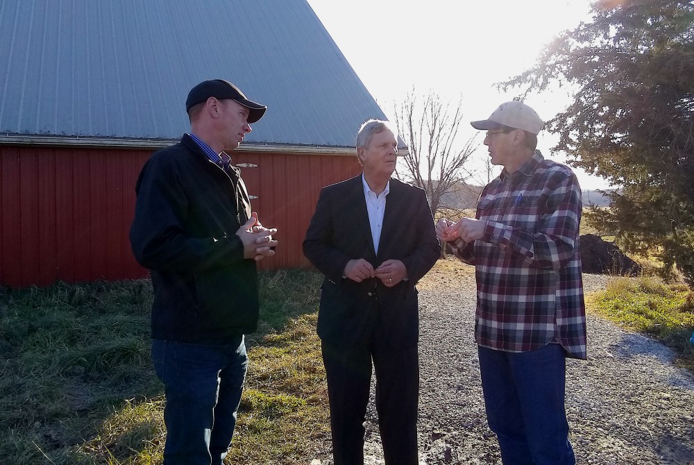 Matt Russell talks with Tom Vilsack, center, secretary of agriculture under President Barack Obama, and his neighbor and fellow farmer Justin Jordan, left. (Provided photo)