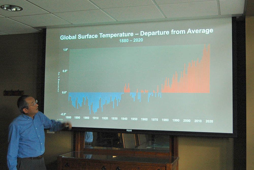 Phil Sakimoto references a slide as he discusses global temperature changes. (William E. O'Dell)