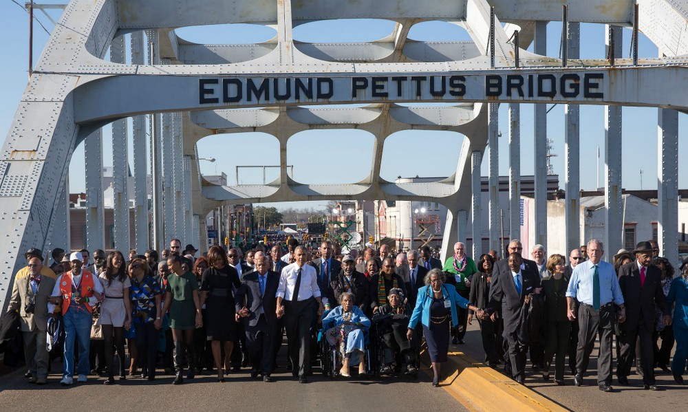 John Lewis walks between first lady Michelle Obama and President Barack Obama during a walk across Edmund Pettus Bridge to commemorate the 50th anniversary of the "Bloody Sunday" march from Selma to Montgomery, in Selma, Alabama, on March 7, 2015.