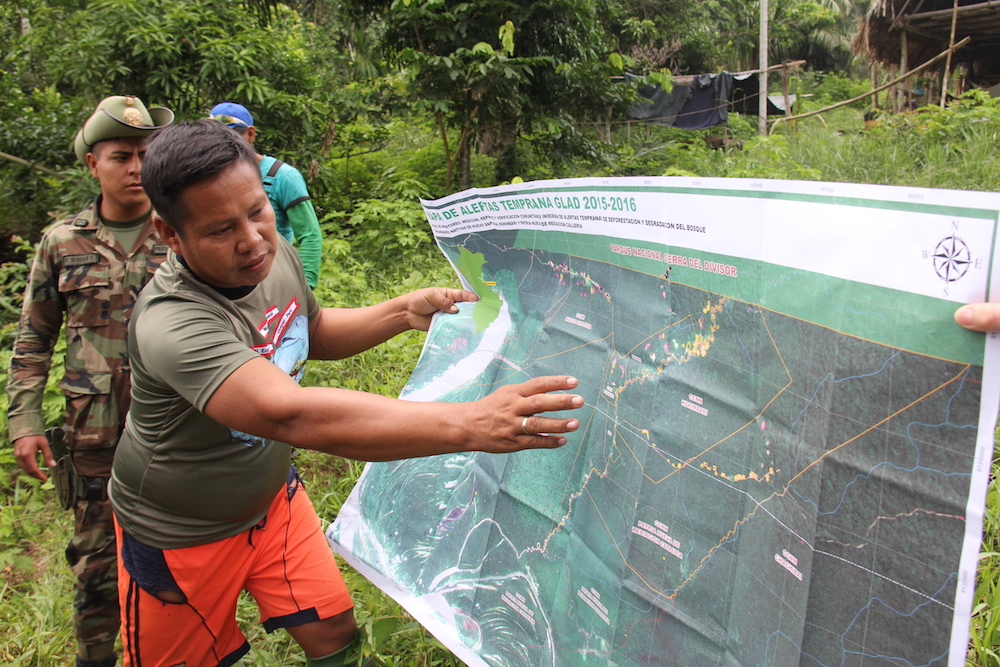 A community leader in Peru's Ucayali region indicates on a map the area where outsiders cleared land to plant coca, the main ingredient in cocaine. (Barbara Fraser)