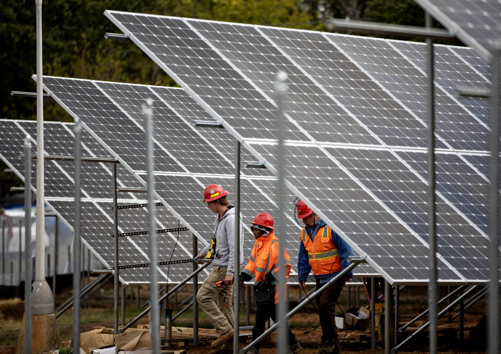 Workers in Washington are seen near solar panels Oct. 17, 2019, on the property of Catholic Charities of the Washington Archdiocese. (CNS/Catholic Standard/Andrew Biraj)