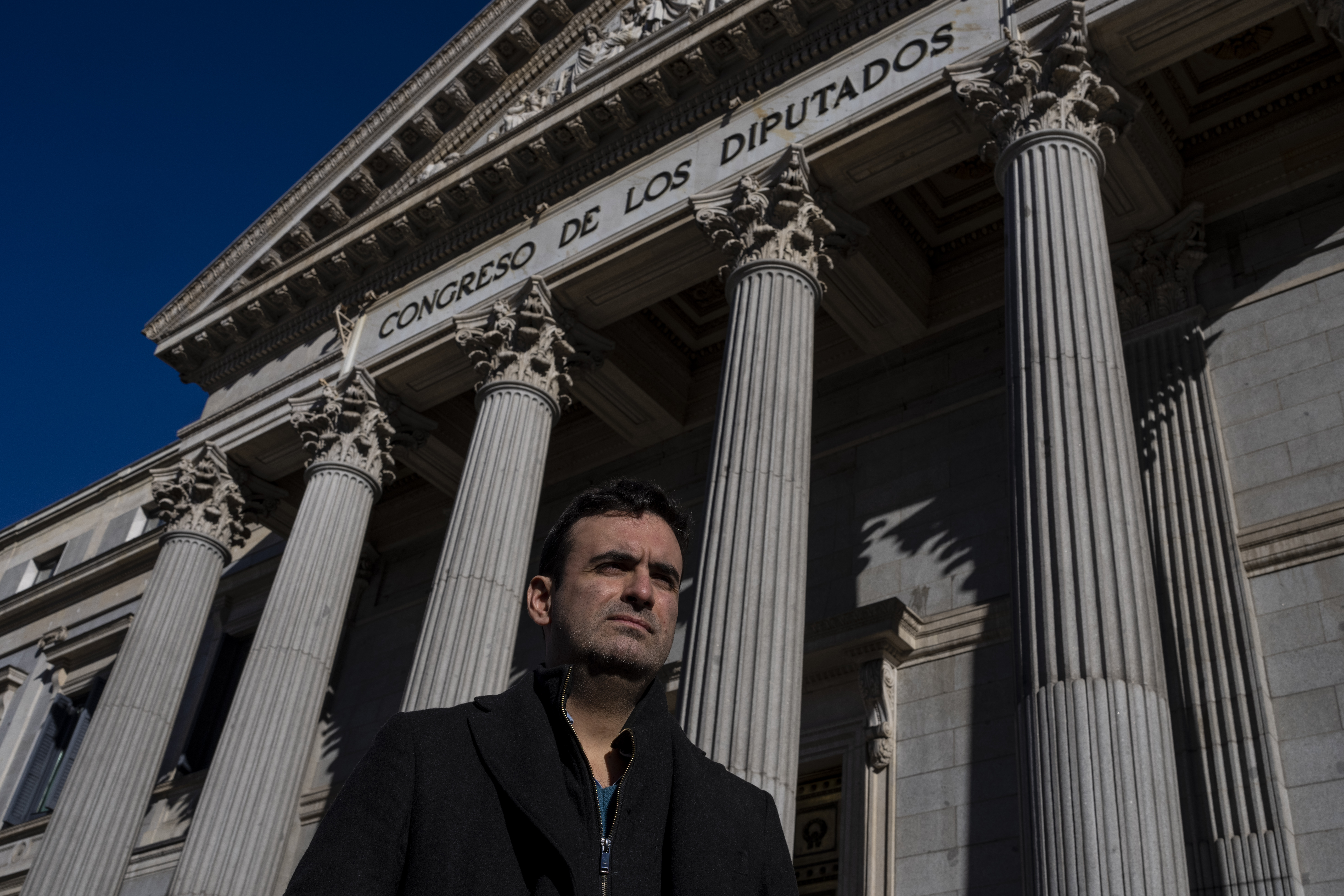 Miguel Hurtado, who has campaigned against impunity since disclosing his own account of being abused at a monastery in northeastern Spain, poses for a picture in front of a Spanish parliament in Madrid, Spain, Tuesday, Feb. 1, 2022. (AP Photo/Manu Fernand