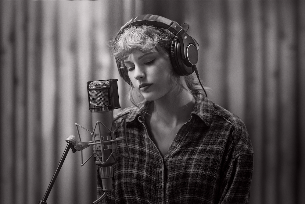 Taylor Swift at a microphone in a studio