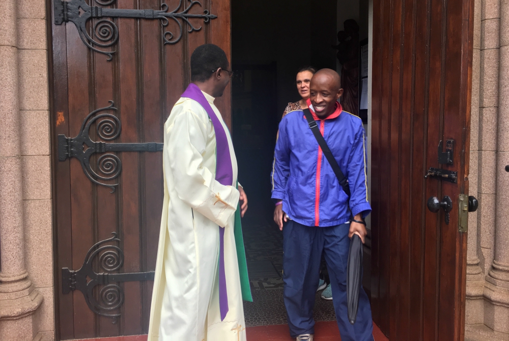 A parishioner talks with Fr. Norbert Munekani after Mass at Holy Trinity Catholic Church in Johannesburg, before the South African government imposed a lockdown to combat the coronavirus outbreak. (Patrick Egwu)
