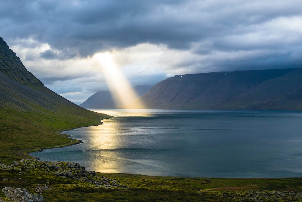 Sunbeam coming down from clouds into a body of water (Unsplash/Davide Cantelli)
