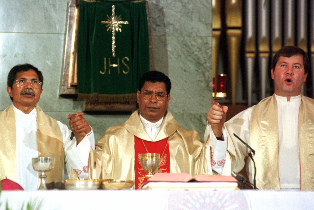 East Timor's Roman Catholic Bishop Carlos Ximenes Belo holds hands with other priests during the Sunday's morning mass at Lisbon's Salesian religious order's church, on Sept. 12, 1999