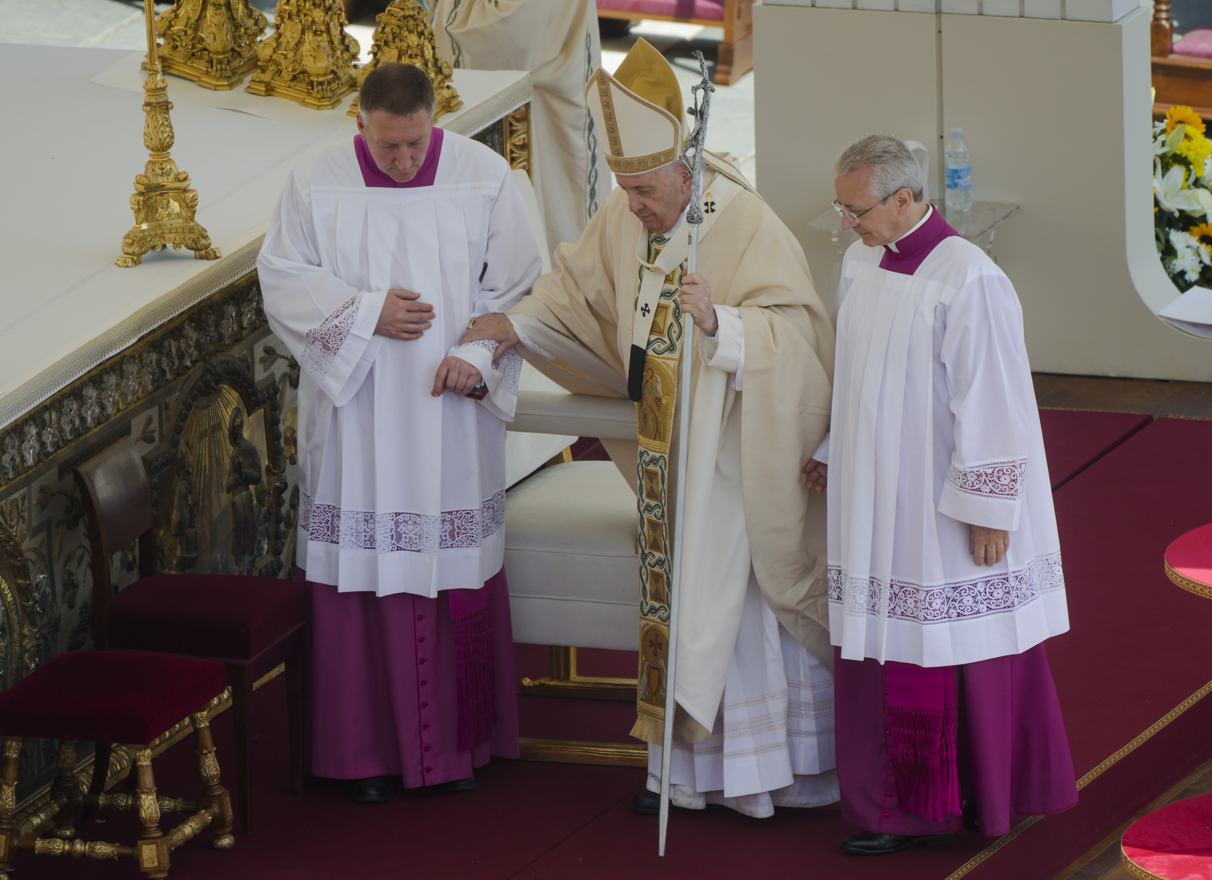 Pope Francis is helped walking as he celebrates the canonization mass for ten new saints in St. Peter's Square at The Vatican, May 15, 2022. (AP Photo/Gregorio Borgia)