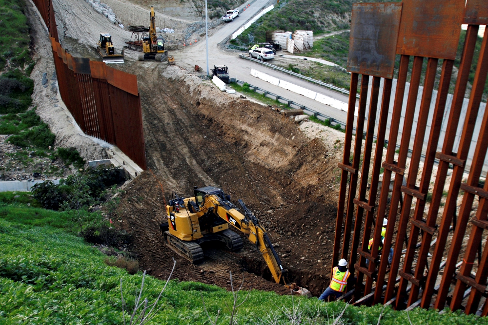 Construction workers in the U.S. work on a new section of the border wall as seen from Tijuana, Mexico, Feb.18. (CNS/Reuters/Jorge Duenes)