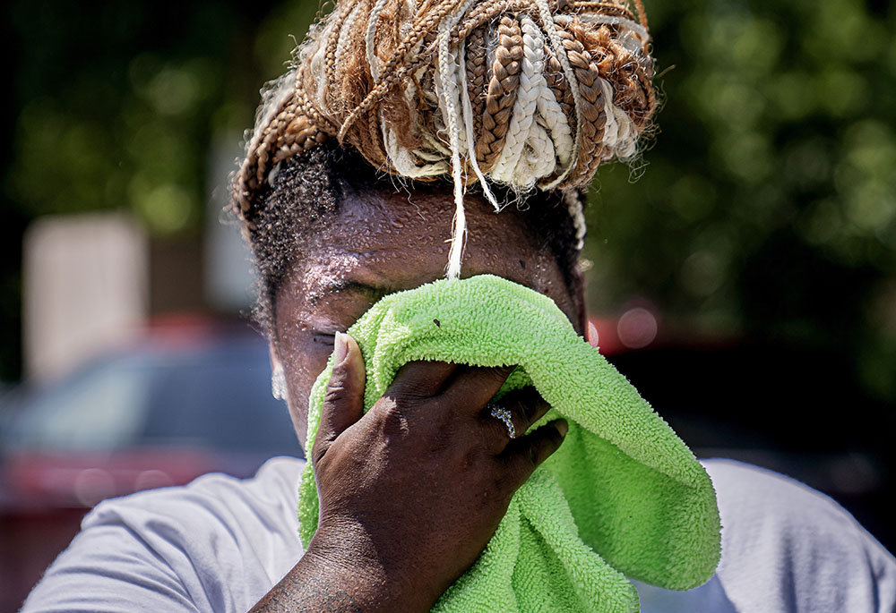 Nicole Brown wipes sweat from her face while setting up her beverage stand near the National Mall July 22, during a heat wave in Washington, D.C. (AP/Nathan Howard)