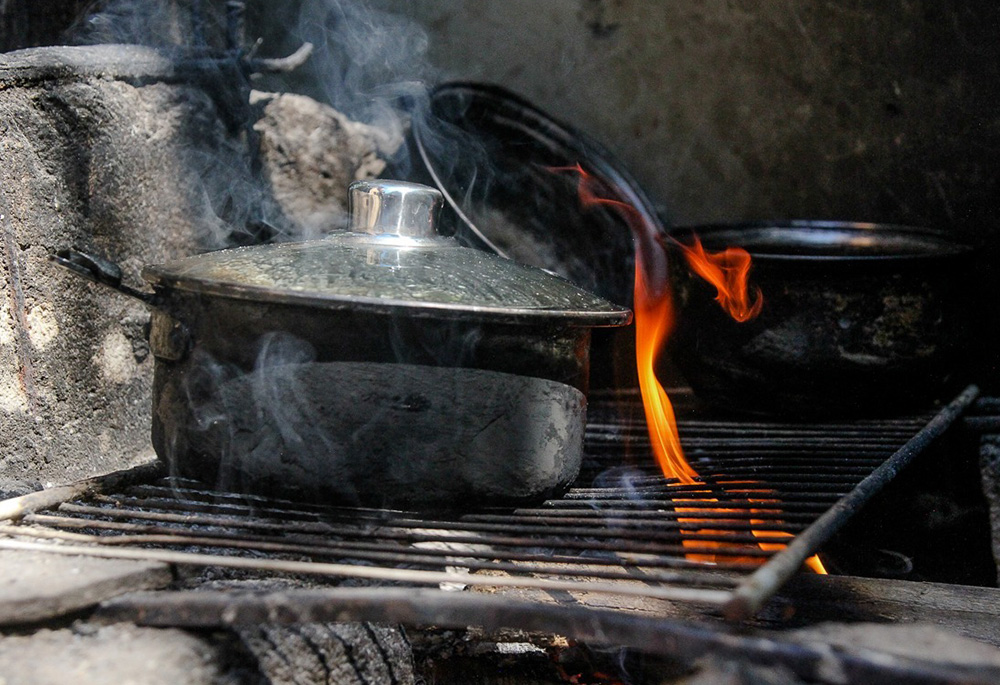 Neilma da Cruz Silva uses scrap wood for cooking fuel in April 2020, in a low-income neighborhood in Rio de Janeiro. (Bruno Itan) Neilma da Cruz Silva uses scrap wood for cooking fuel in April 2020, in a low-income neighborhood in Rio de Janeiro. (Bruno Itan)