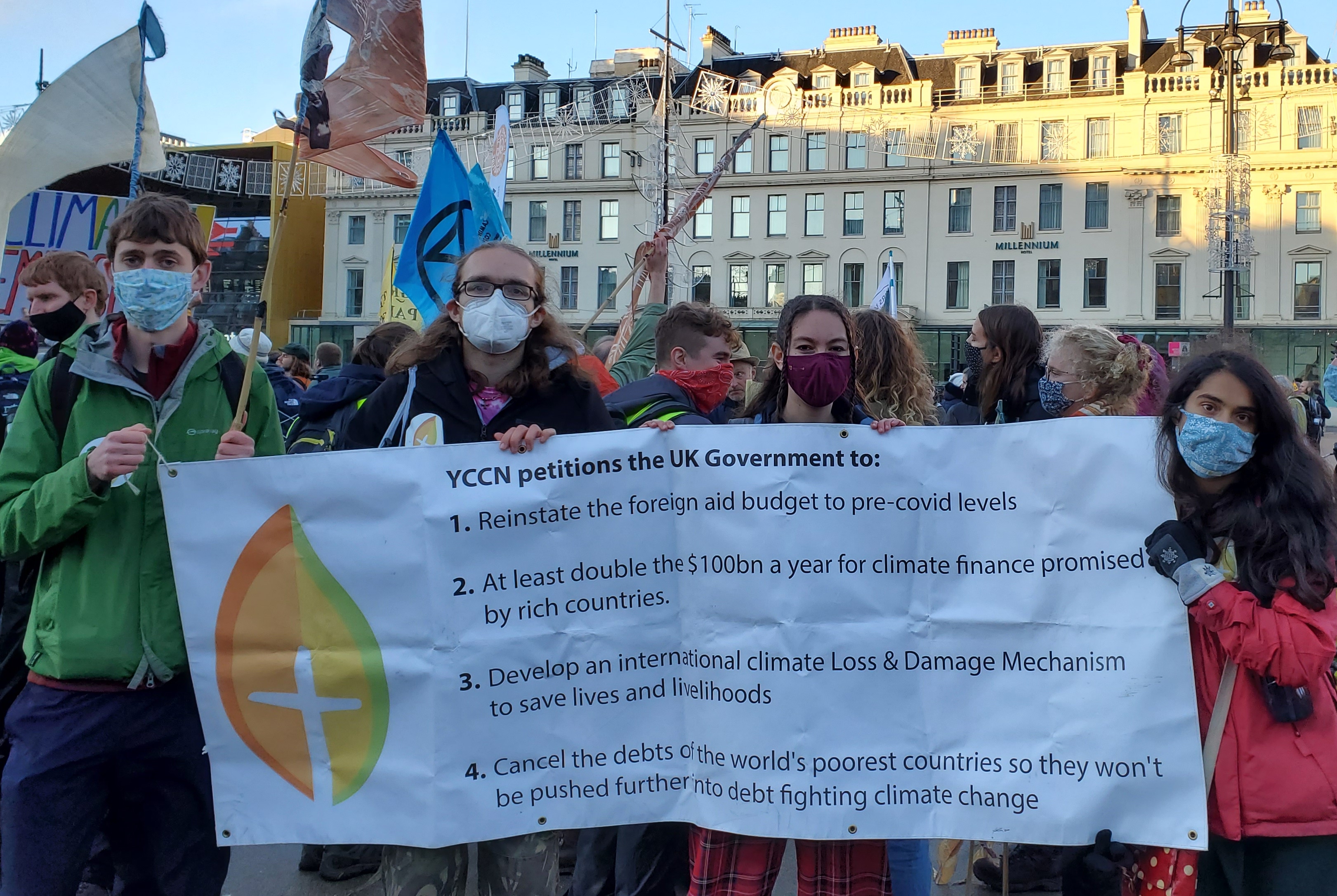 Members of the Young Christian Climate Network display a banner stating their petitions for climate justice. (NCR/Brian Roewe)