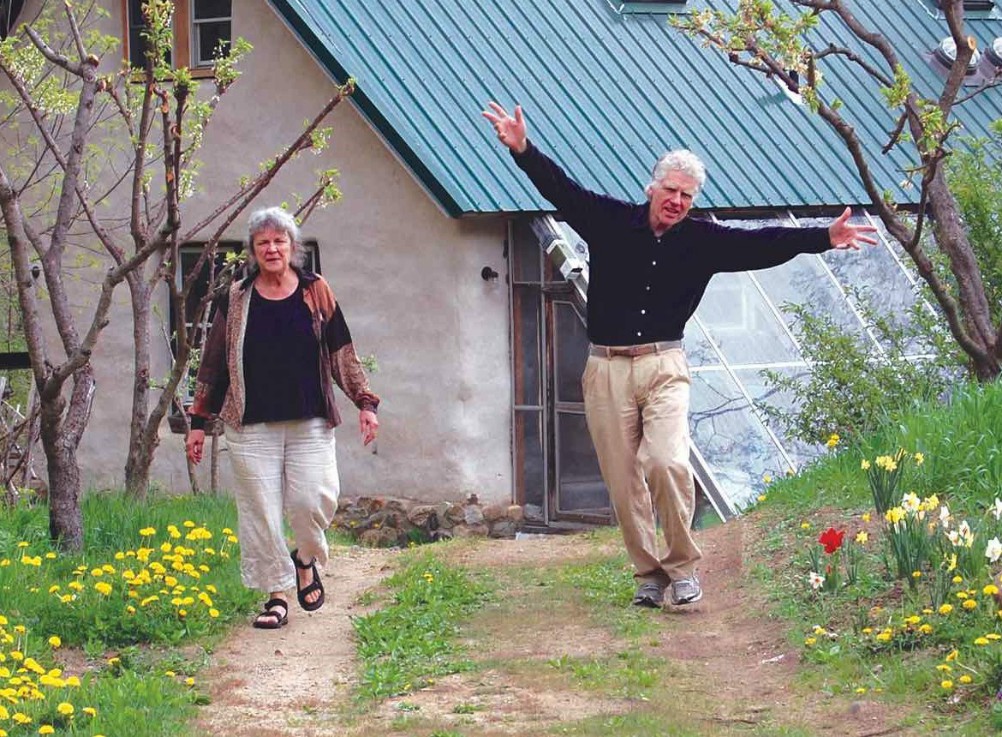 Suzanne Belote Shanley and Brayton Shanley of the Agape Community, with a house constructed of bales of straw in the background (Claudia McNeil)