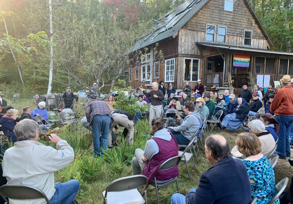 Brayton Shanley speaks at Agape's St. Francis Day event in October 2019, with Francis House in the background (Bill Mitchell)