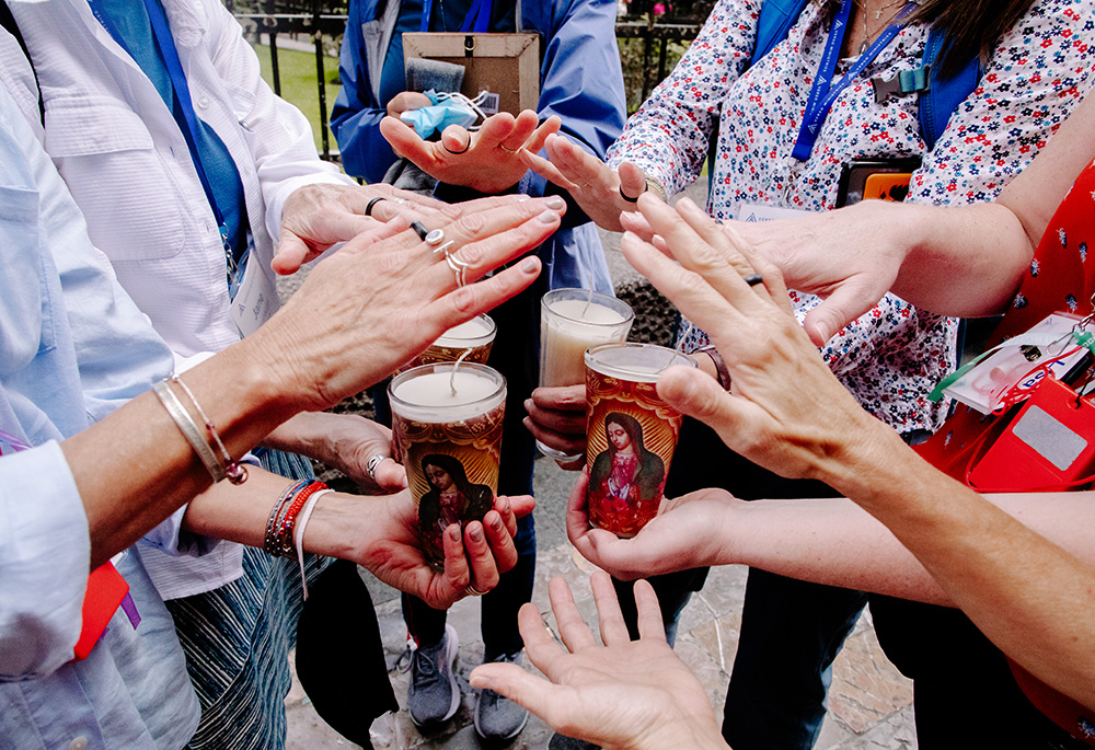 Pilgrims offer prayers and bless candles they bought at the Shrine of Our Lady of Guadalupe in Mexico City, as they prepare to climb the hill at Tepeyac. Discerning Deacons held a pilgrimage to Mexico City Aug. 31-Sept. 3. (Luisa Arumi Ortiz)