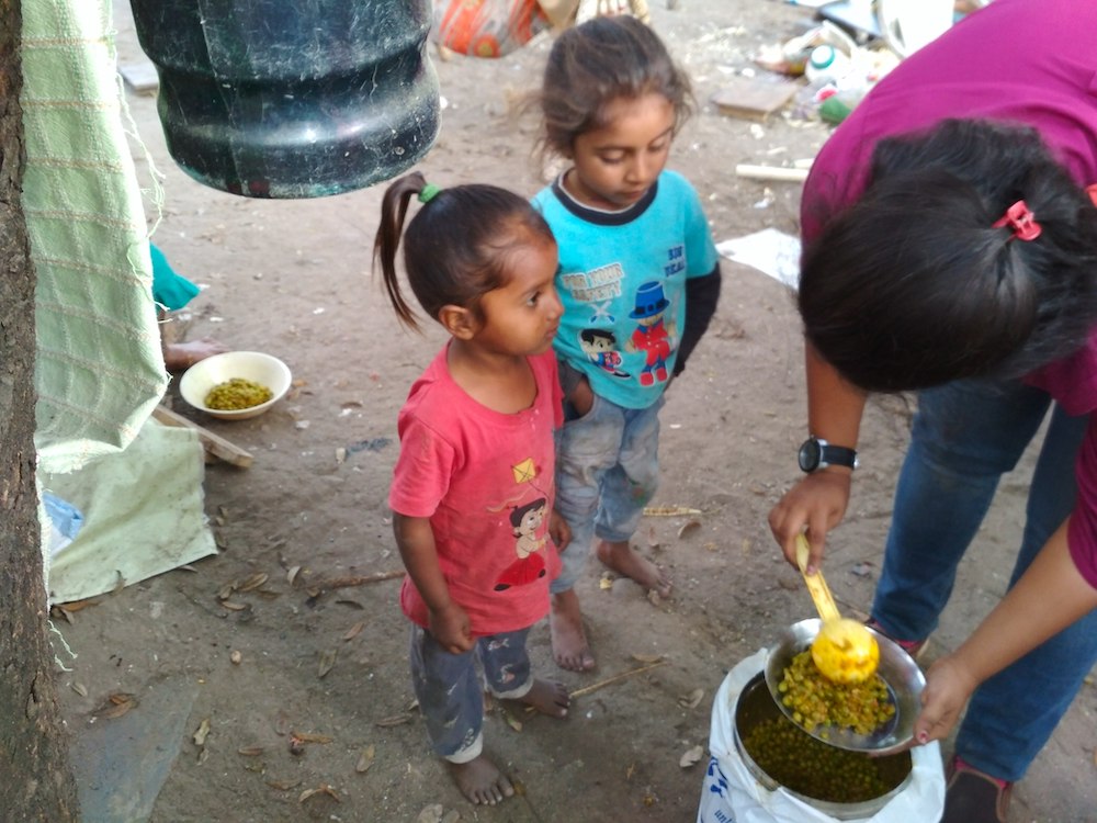 Children receive a meal from "Robinhood army," which collects food from hotels and restaurants in India to give to people who need it, pictured February 2019. (Wikimedia Commons/Rajesh)