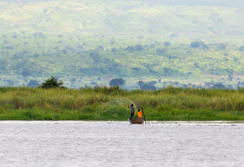Two fishermen throw a net out on Lake Albert in Uganda. (Dreamstime/Mathias Sunke)