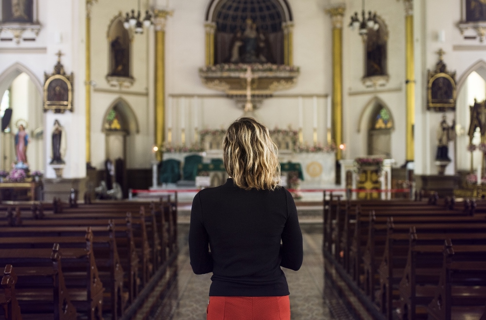 Young woman in a church (Dreamstime/Rawpixelimages)