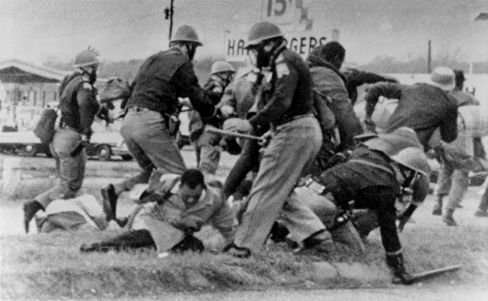 An Alabama State Trooper swings his club at John Lewis' head during the civil rights march across the Edmund Pettus Bridge in Selma, Alabama, on May 7, 1965. (Newscom/Everett Collection)