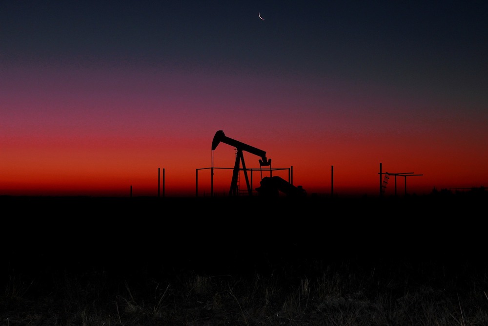An oil rig is seen at sunset. Fossil fuel companies have shifted from outright climate change denialism to subtler delaying tactics, with messages that downplay the seriousness of global warming. (Pixabay/James Armbruster)