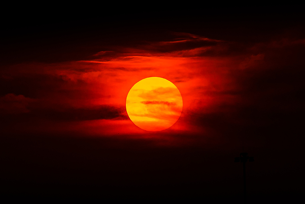 Photo illustration of a sun surrounded by clouds (Unsplash/Jared Murray)