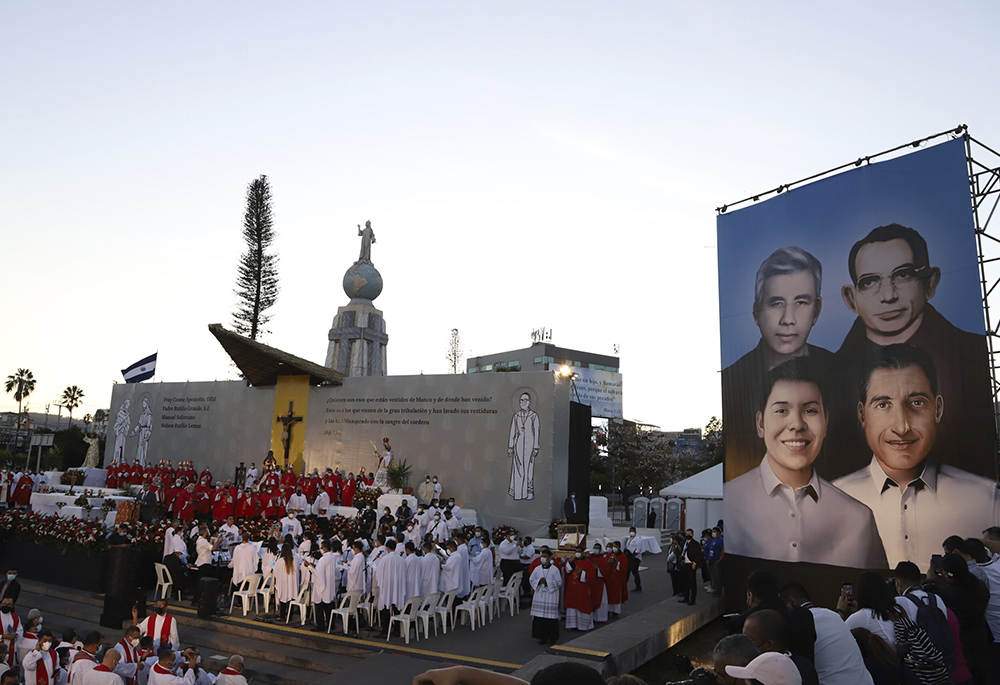 A poster depicting the Rev. Rutilio Grande, Franciscan priest Cosme Spessotto, Nelson Lemus and Manuel Solorzano, all victims of right-wing death squads during El Salvador's civil war, is shown during a beatification ceremony Jan. 22 in San Salvador. (AP)